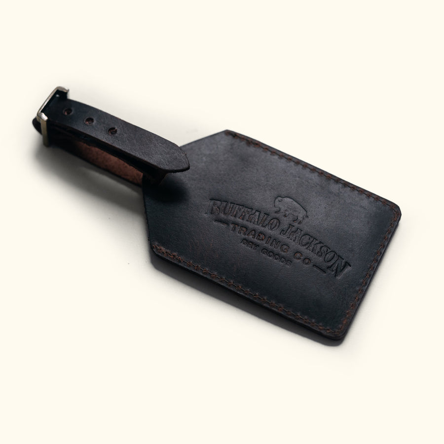 Luxurious dark oak leather tag for luggage, crafted with fine stitching details.