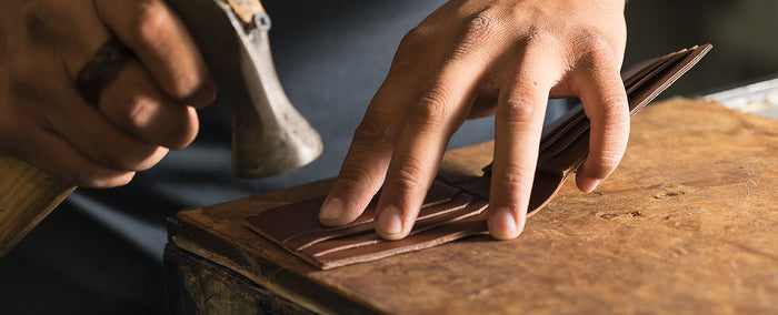 Craftsman's hands working a piece of leather