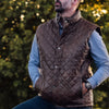 Detailed view of a quilted brown leather vest, highlighting its sleek design and craftsmanship.