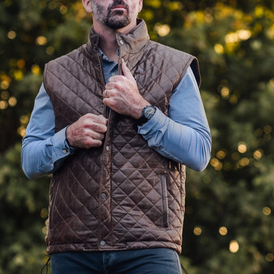 Stylish brown leather vest with a diamond quilt pattern and multiple pockets.