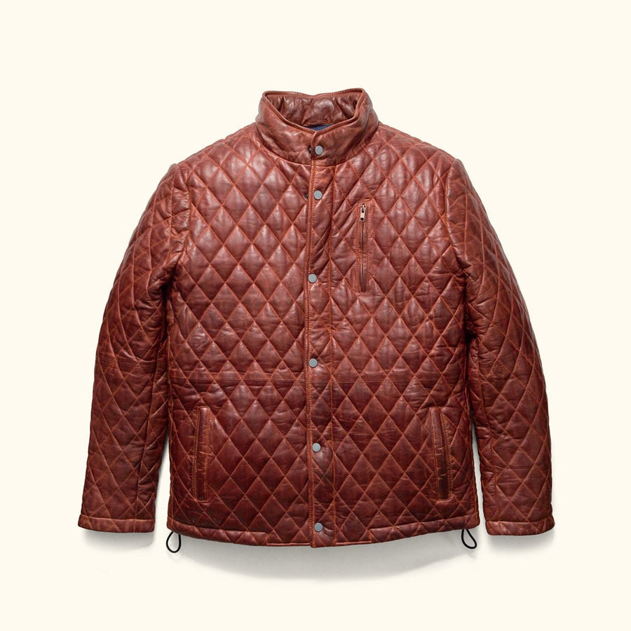 Man in the Highlands Quilted Leather Jacket in Whiskey Brown in a doorway, carrying a black leather briefcase.