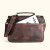 Durable dark oak leather briefcase with adjustable strap and traditional buckle closures, ideal for office or travel.