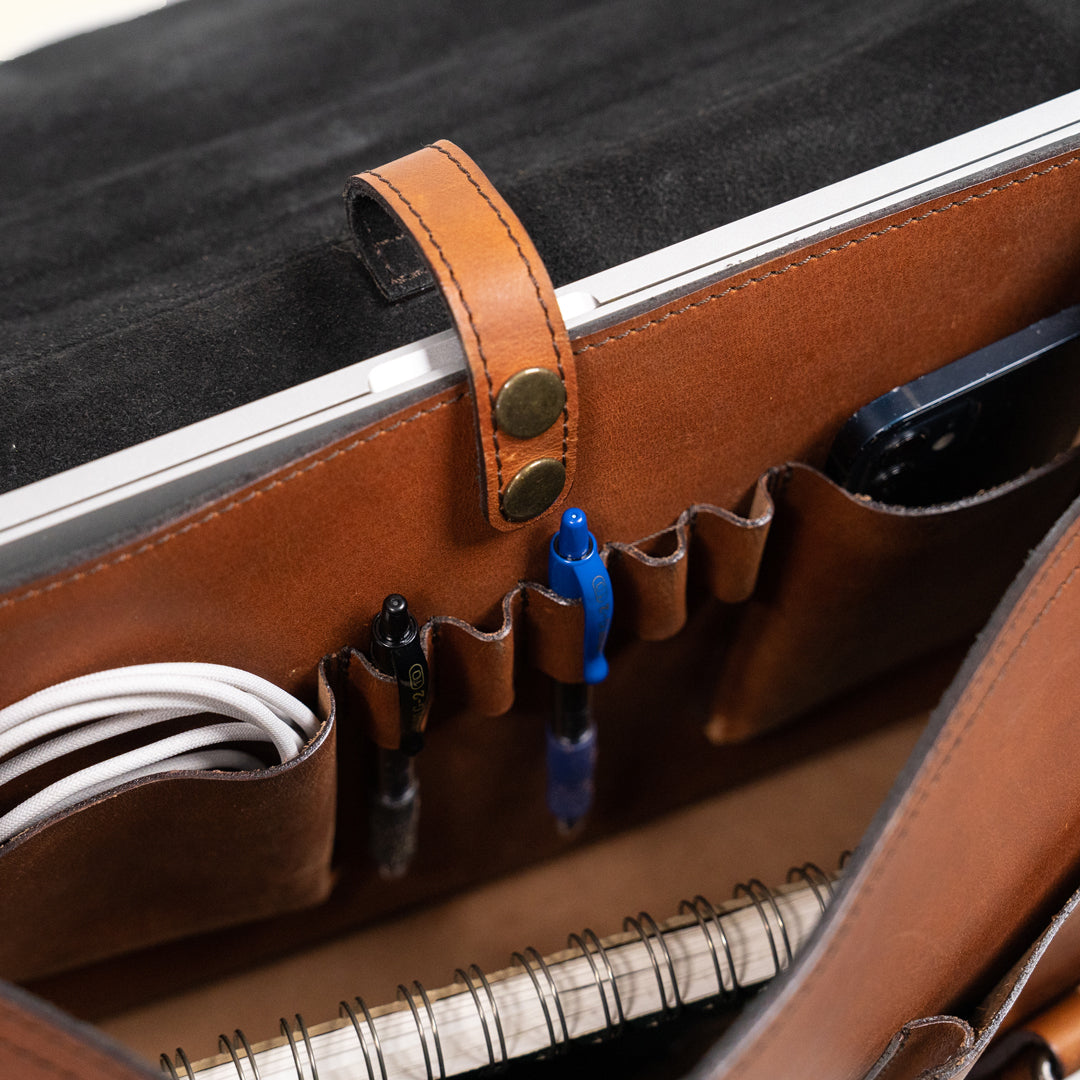 Luxurious amber brown leather briefcase featuring a spacious interior and sturdy leather handle for professional use.