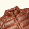 Close-up of a brown leather vest, featuring a durable zipper and intricate quilted pattern.