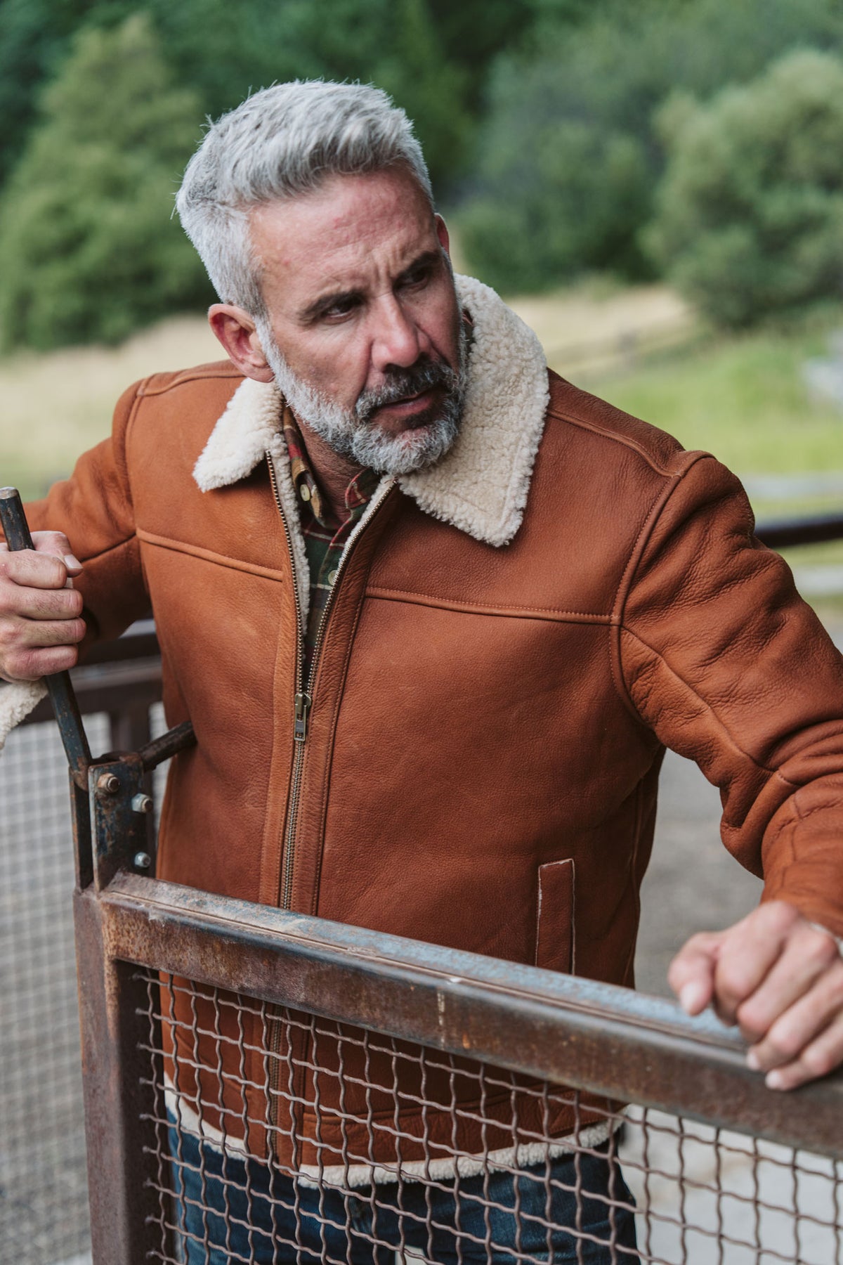 Man wearing a whiskey brown shearling bomber jacket outdoors on a cold day