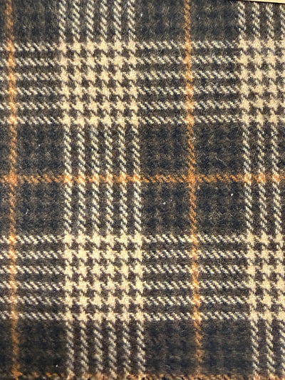 Close-up of a plaid fabric with brown, black, and beige colors.