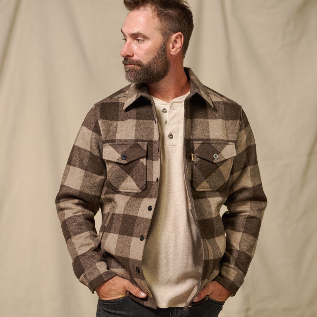 Man wearing the Yukon Wool Shirt Jac in Timber Brown Ash buffalo check with hands in pockets