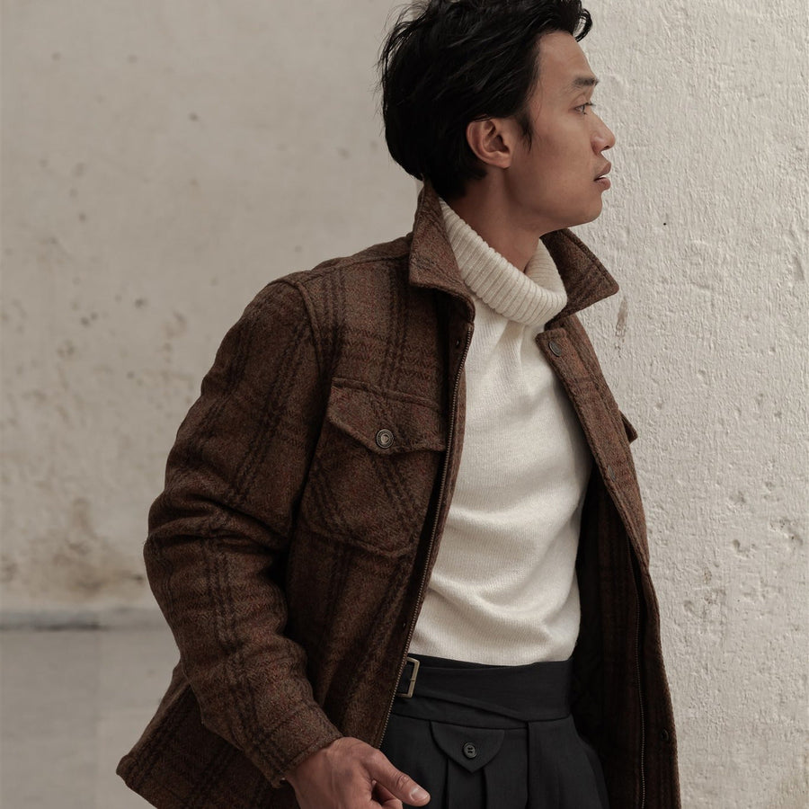 Man in the Aberdeen Wool Jacket in Dunbar Thicket over a cream turtleneck in a white stone arcade