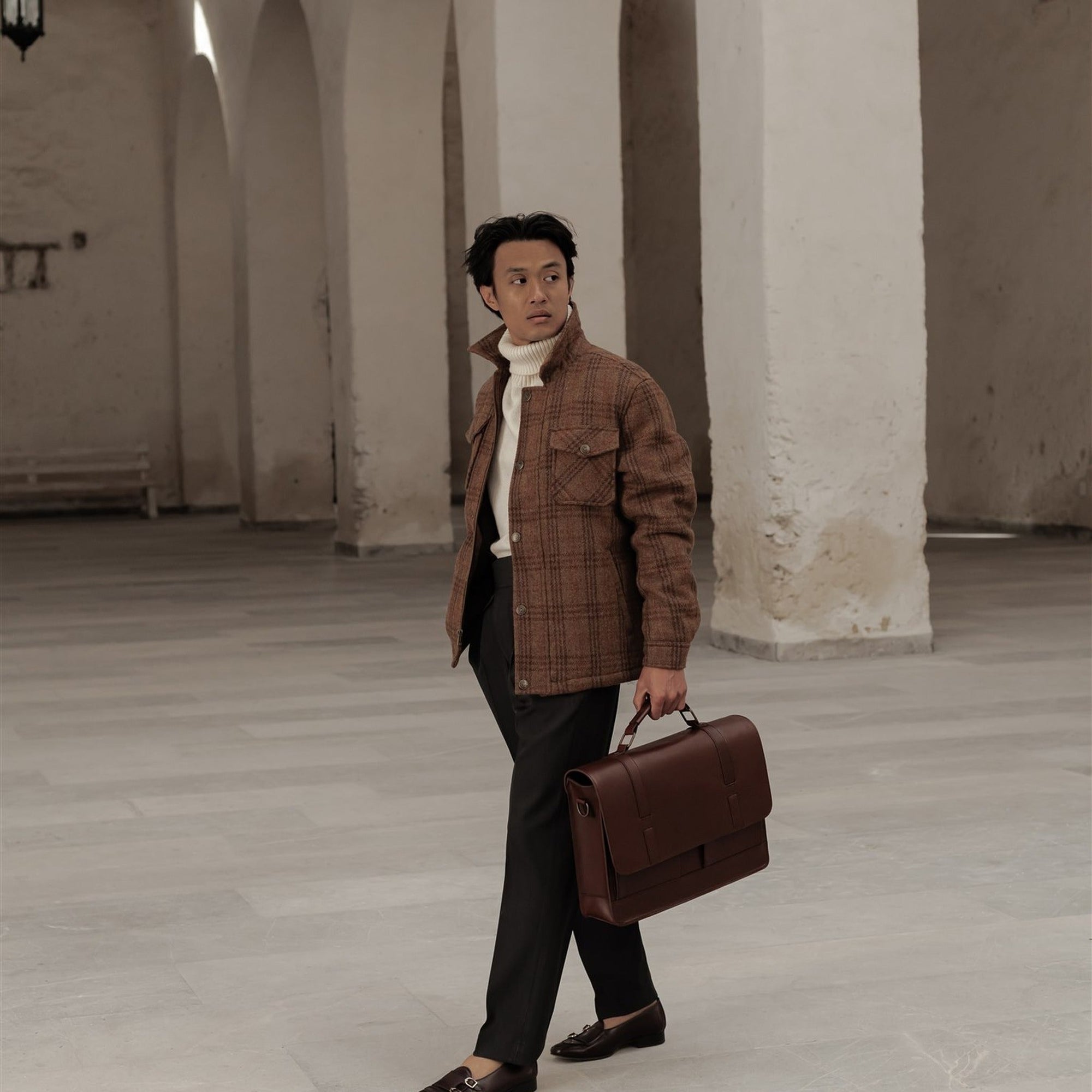 Man in the Aberdeen Wool Jacket in Dunbar Thicket walking through an arcade with a leather briefcase