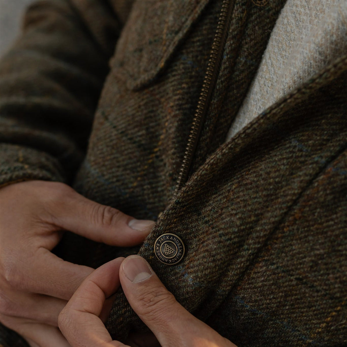Hands at the buttons of the Aberdeen Wool Jacket in Fir Heather
