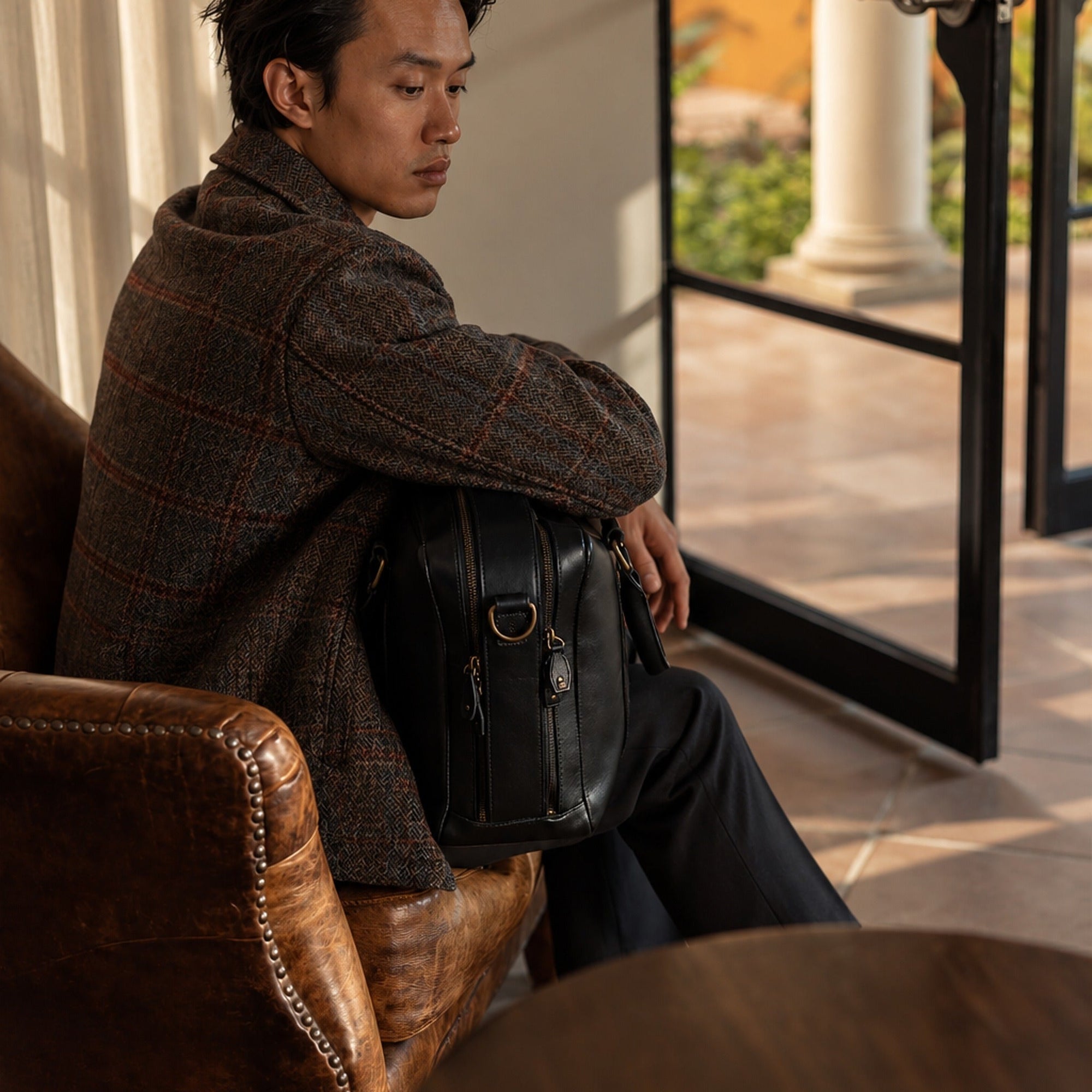 Man in the Aberdeen Wool Jacket in Grey Briar seated by an open door