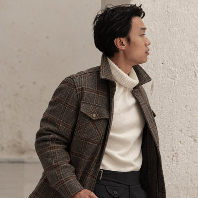 Man in the Aberdeen Wool Jacket in Grey Briar in profile against a white wall