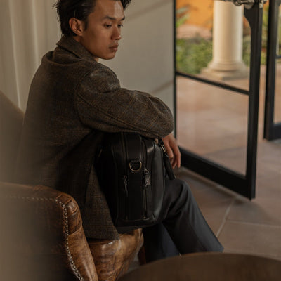 Man in the Aberdeen Wool Jacket in Thistle Bark Plaid seated by a tall window