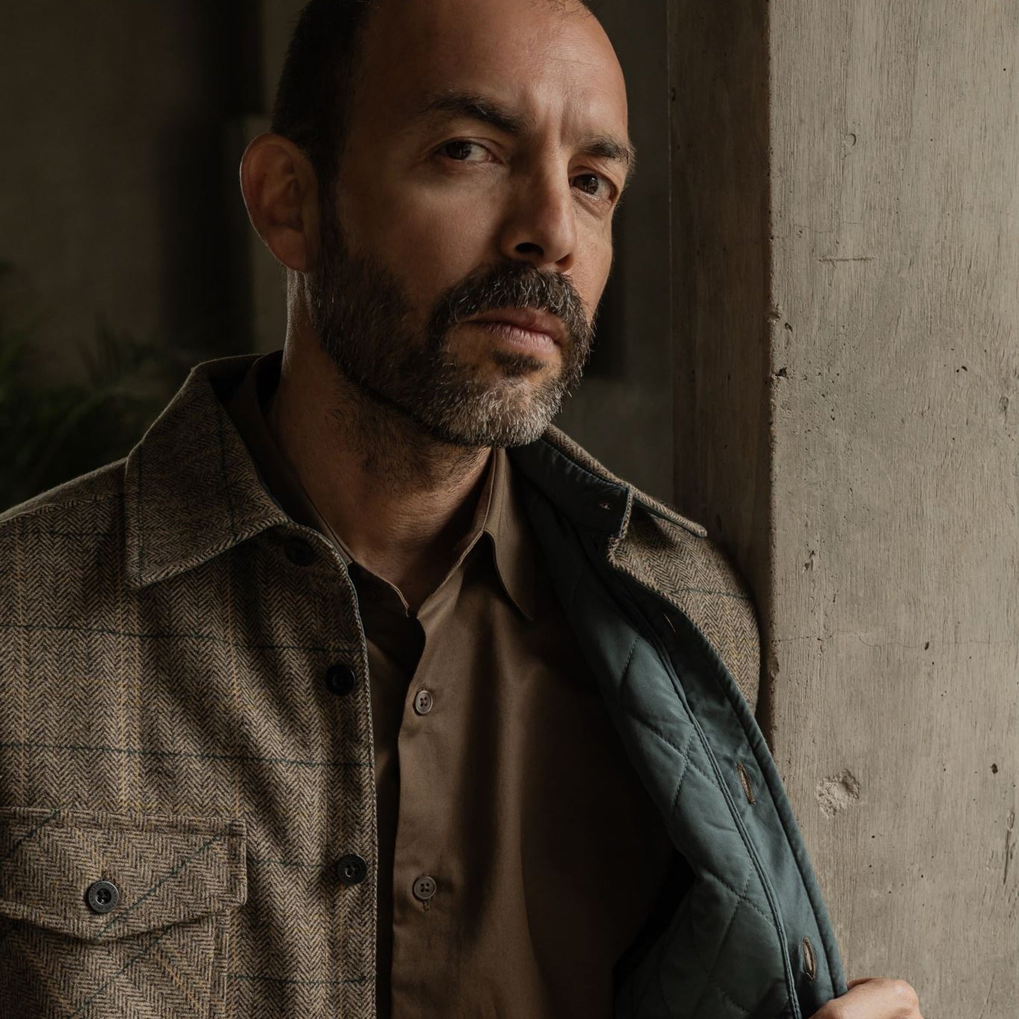 Man holding open the Aberdeen Wool Twill Shirt Jac in Thistle Grove to show the quilted lining