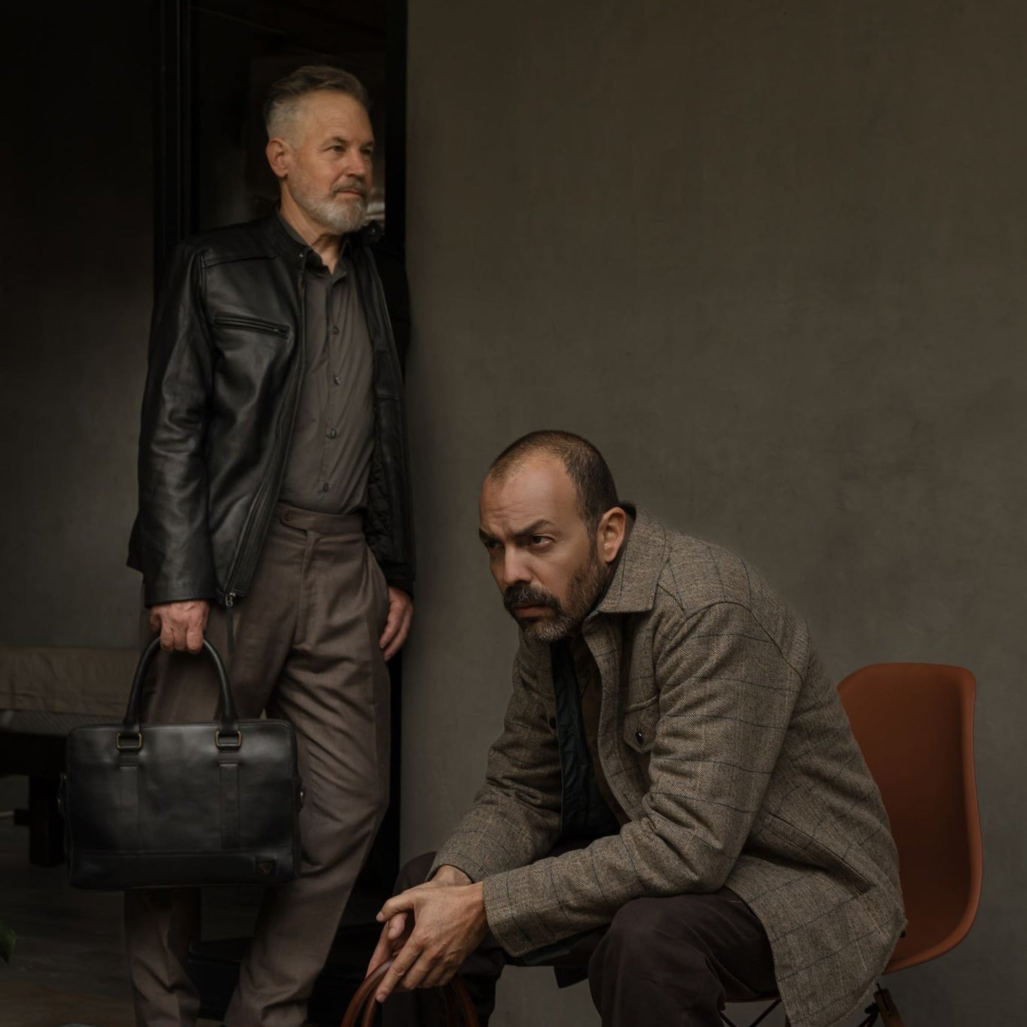 Seated man in the Aberdeen Wool Twill Shirt Jac in Thistle Grove with a leather briefcase