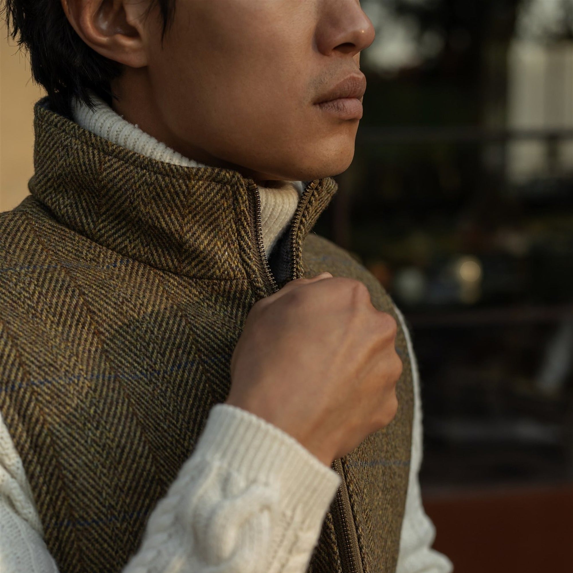 Hand at the stand collar of the Ashton Wool Herringbone Vest in Mosswood