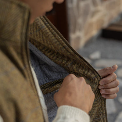 Opening the Ashton Wool Herringbone Vest in Mosswood to show the light blue quilted lining