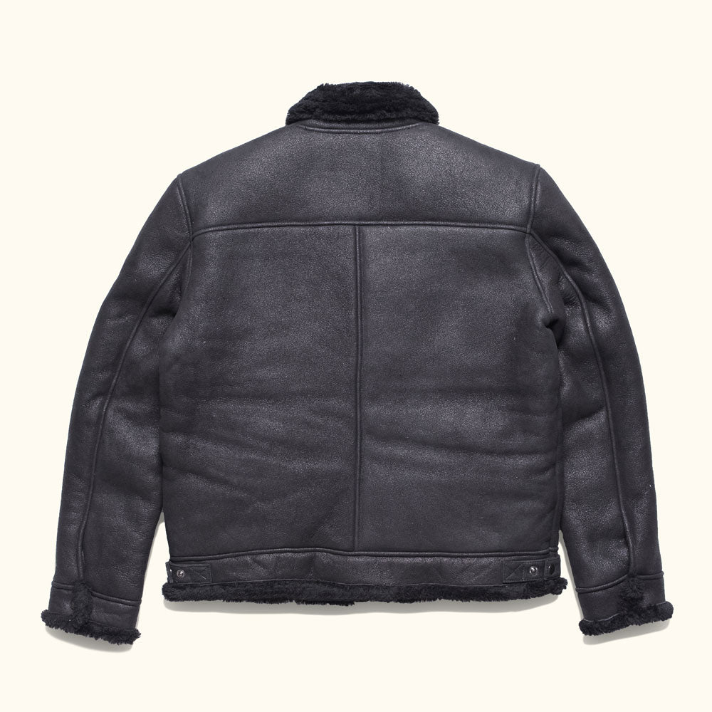 Back view of a black shearling leather bomber jacket descended from the Second World War B-3 flying jacket