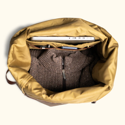 Spacious interior of a canvas backpack, showcasing organized storage for a sweater and laptop.