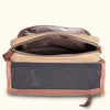 Interior view of a waxed canvas toiletry kit, featuring organized pockets and a zip closure.