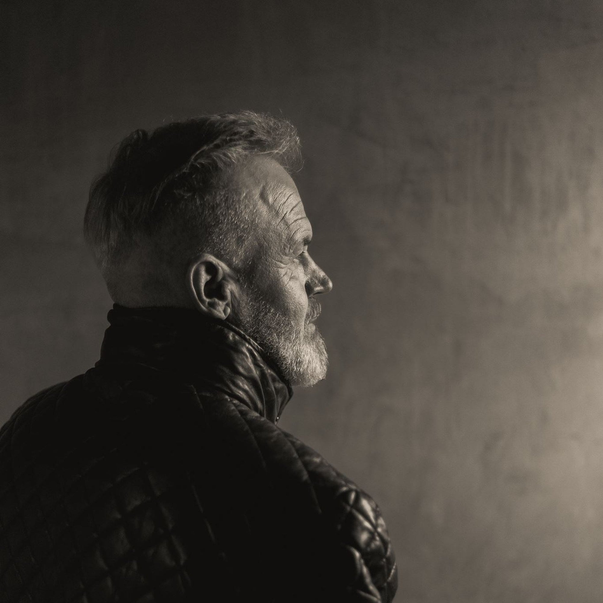 Profile of a man in the Highlands Quilted Leather Jacket in Black against a plain wall.