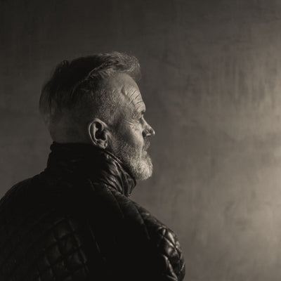 Profile of a man in the Highlands Quilted Leather Jacket in Black against a plain wall.