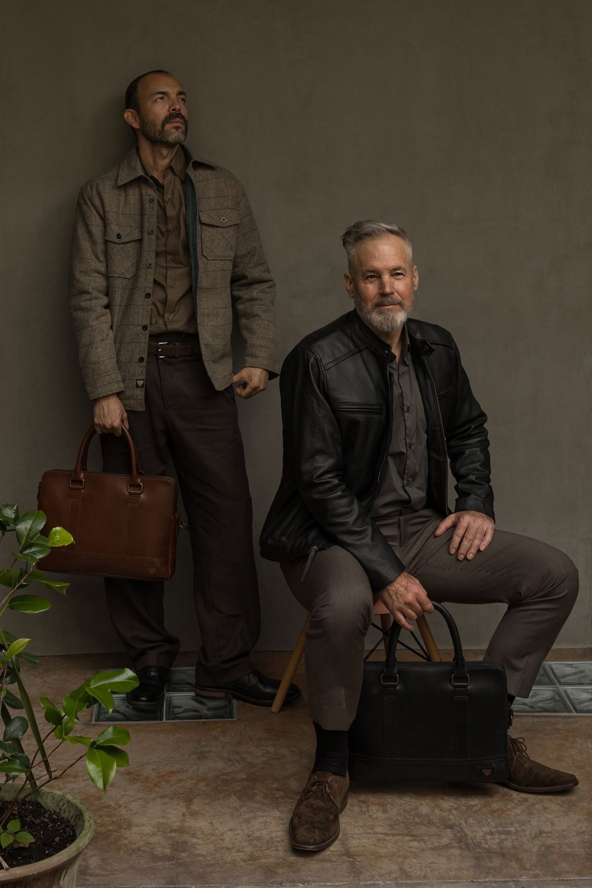 Two men in a Jack Andrews wool shirt jac and black leather jacket, with a Jefferson bag