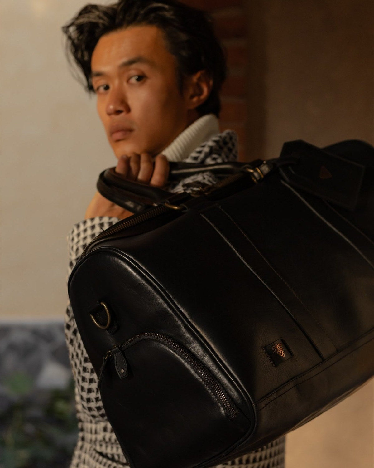 Man carrying the Jefferson Leather Duffle in Vintage Black over his shoulder