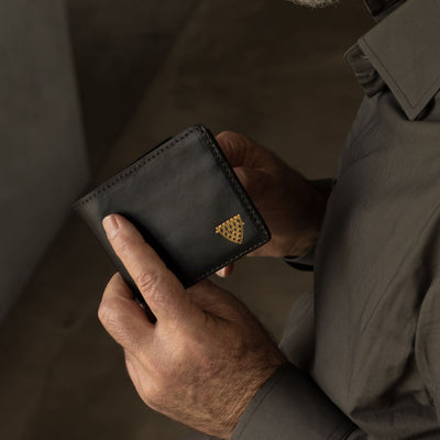 Man holding the Jefferson Leather Bifold Wallet in Vintage Black.