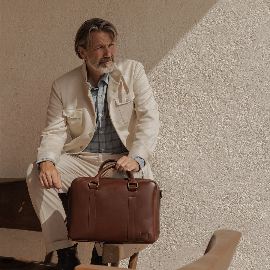 Jefferson Leather Briefcase in Elderwood Brown, front three-quarter view with shoulder strap.
