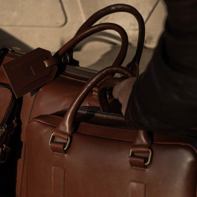 Close-up of the Jefferson Leather Briefcase in Elderwood Brown packed in a vintage car trunk.