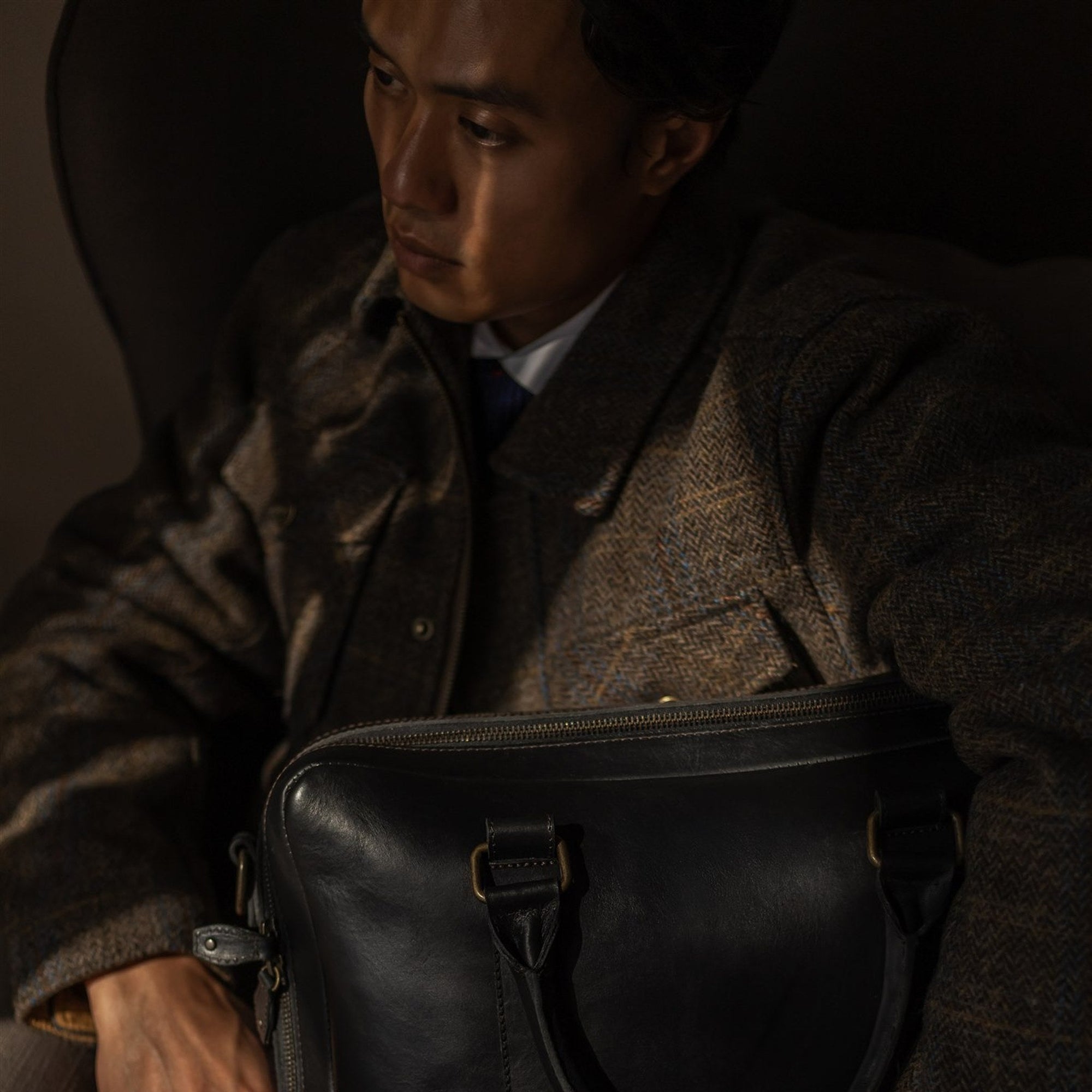 Man seated with the Jefferson Leather Briefcase in Vintage Black on his lap.