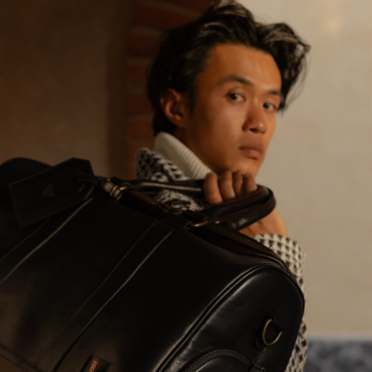 Man carrying the Jefferson Leather Duffle in Vintage Black over his shoulder.