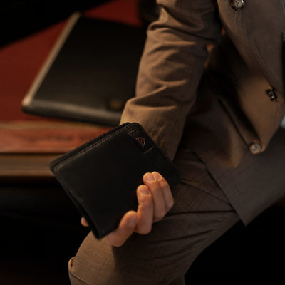 The Jefferson Leather Passport Wallet in Vintage Black held in one hand.