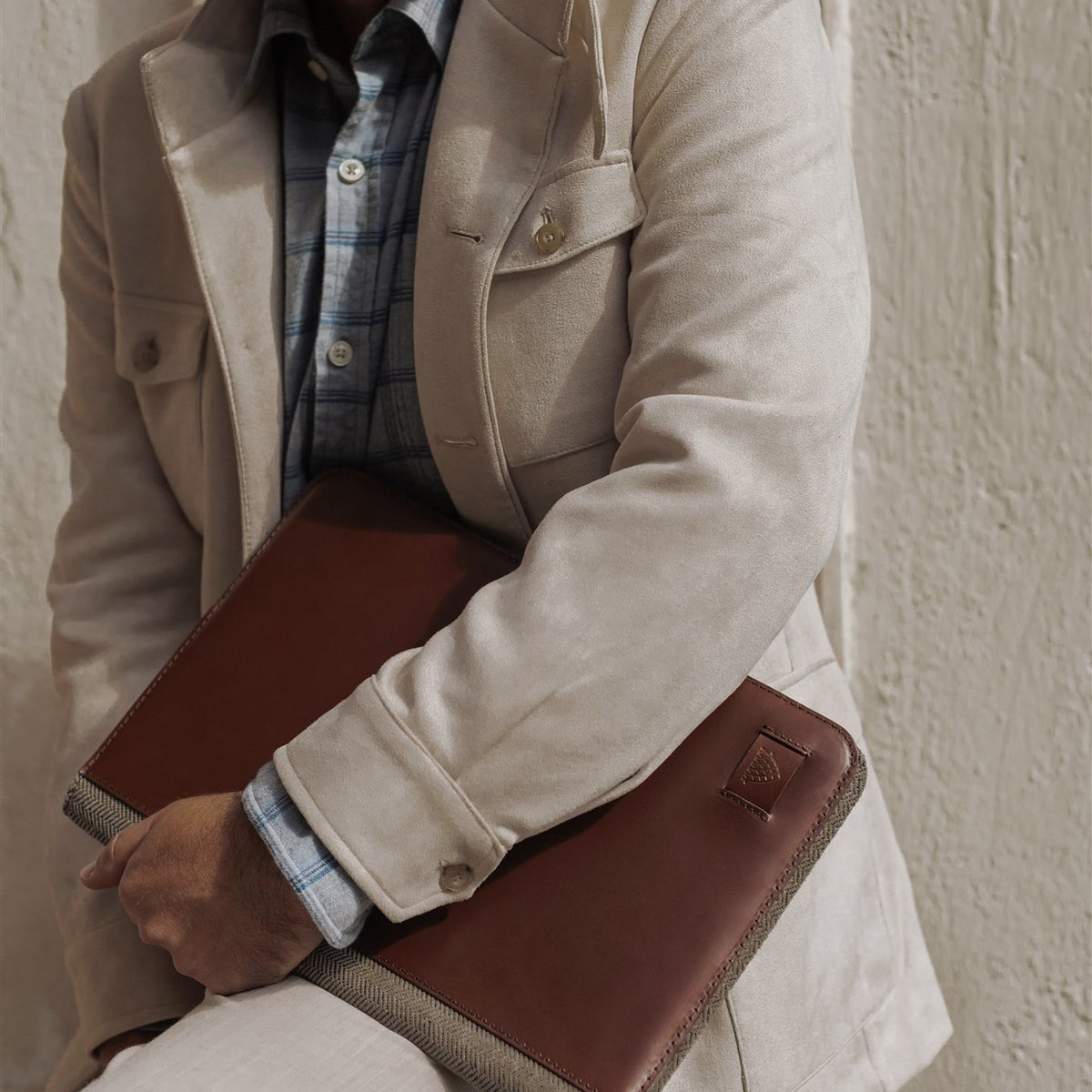 Man holding the Jefferson Leather Travel Portfolio in Elderwood Brown under his arm.