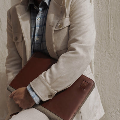 Man holding the Jefferson Leather Travel Portfolio in Elderwood Brown under his arm.