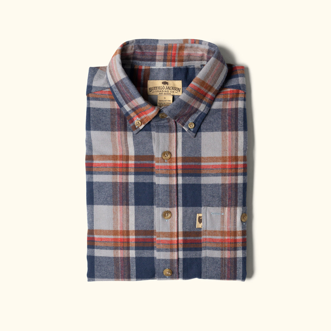 Folded plaid shirt with visible brand label on a white background