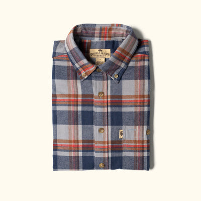 Folded plaid shirt with visible brand label on a white background