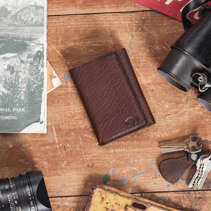 Elegant dark brown water buffalo leather wallet with a trifold design and subtle embossed logo.