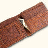 Close-up of an open brown bison leather wallet, revealing a secure cash compartment.