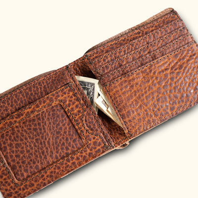 Close-up of an open brown bison leather wallet, revealing a secure cash compartment.