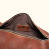 Simple and spacious interior of a brown leather duffle bag, ideal for organized packing.