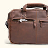 Brown leather bag showcasing its zippered front pocket, ideal for cables and quick-access items.