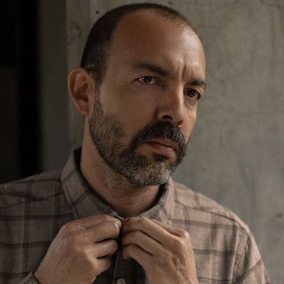 Man buttoning the collar of the Windsor Cotton Shirt in Timber Pane