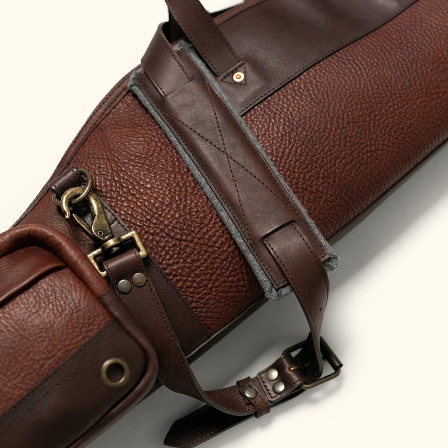 Close detail of antique brass buckle hardware and copper rivets on a full grain leather rifle case