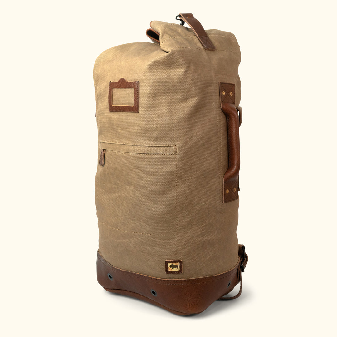 https://buffalojackson.com/cdn/shop/products/Dakota_Waxed_Canvas_Military_Sea_Bag_Backpack_Field_Khaki_With_Chestnut_Brown_Leather_-_2-of-6.jpg?v=1685114240