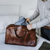 Sophisticated leather carryall, ideal for travel, with ample space, secure zippers, and a timeless design.
