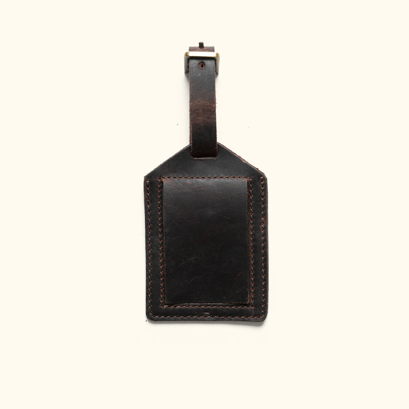 Luxurious dark oak leather tag for luggage, crafted with fine stitching details.