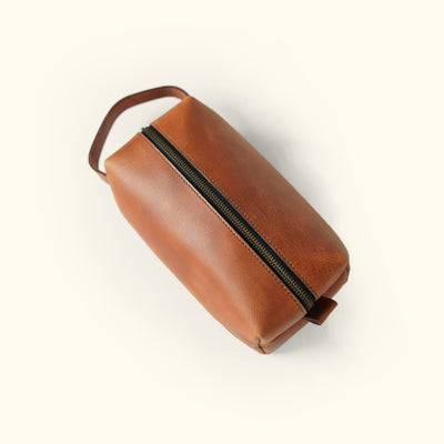 Roosevelt travel toiletry bag in rich amber brown leather, perfect for organizing personal items.