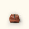 Compact amber brown buffalo leather grooming bag with a sleek, minimalist aesthetic.